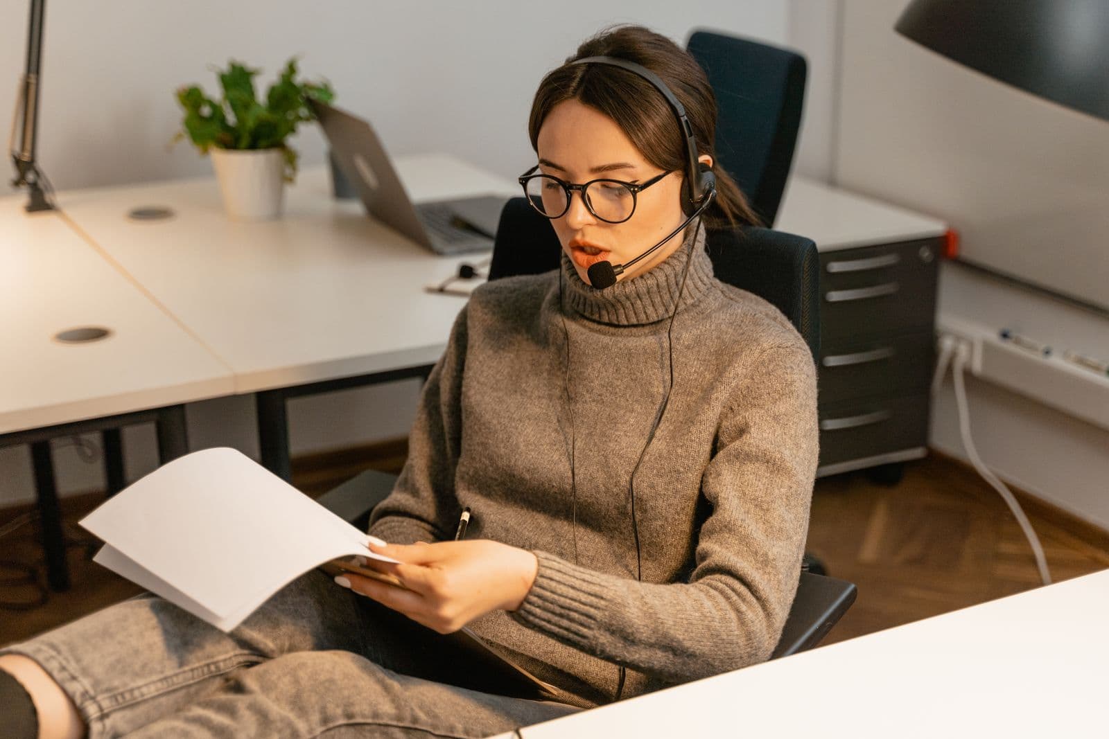 A quality reviewer wearing a headset and checking written call notes